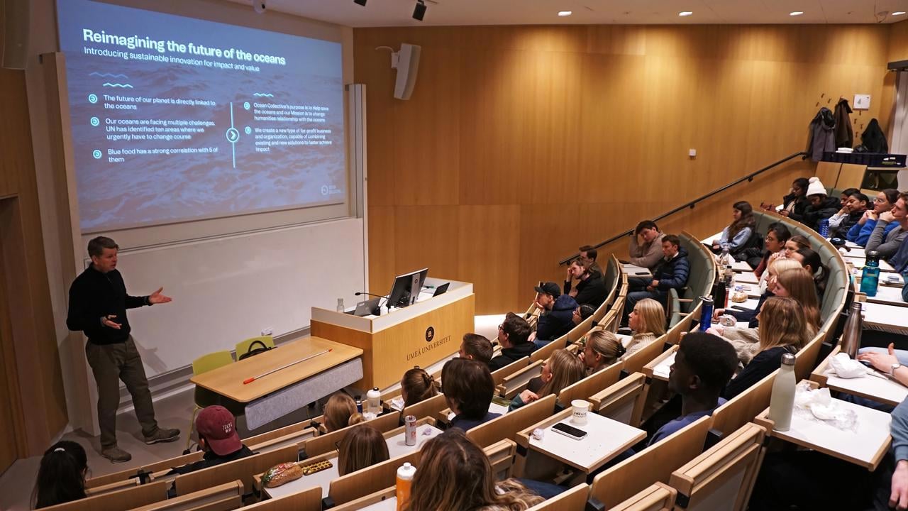 A man giving a lecture to a group of people.
