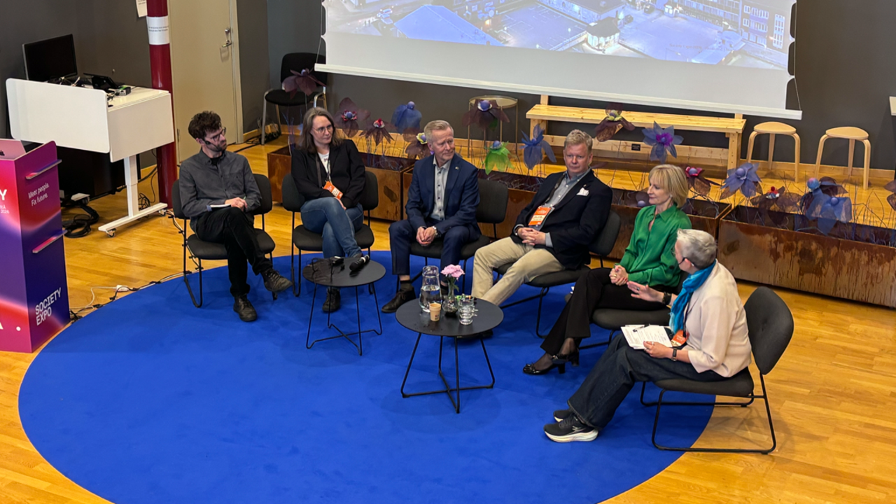 En grupp m&auml;nniskor som sitter p&aring; stolar framf&ouml;r en projektorsk&auml;rm.