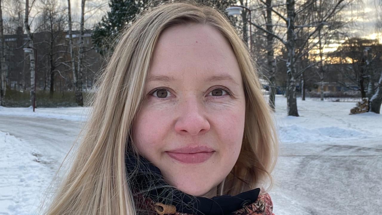 En kvinna med l&aring;ngt blont h&aring;r st&aring;r i sn&ouml;n.