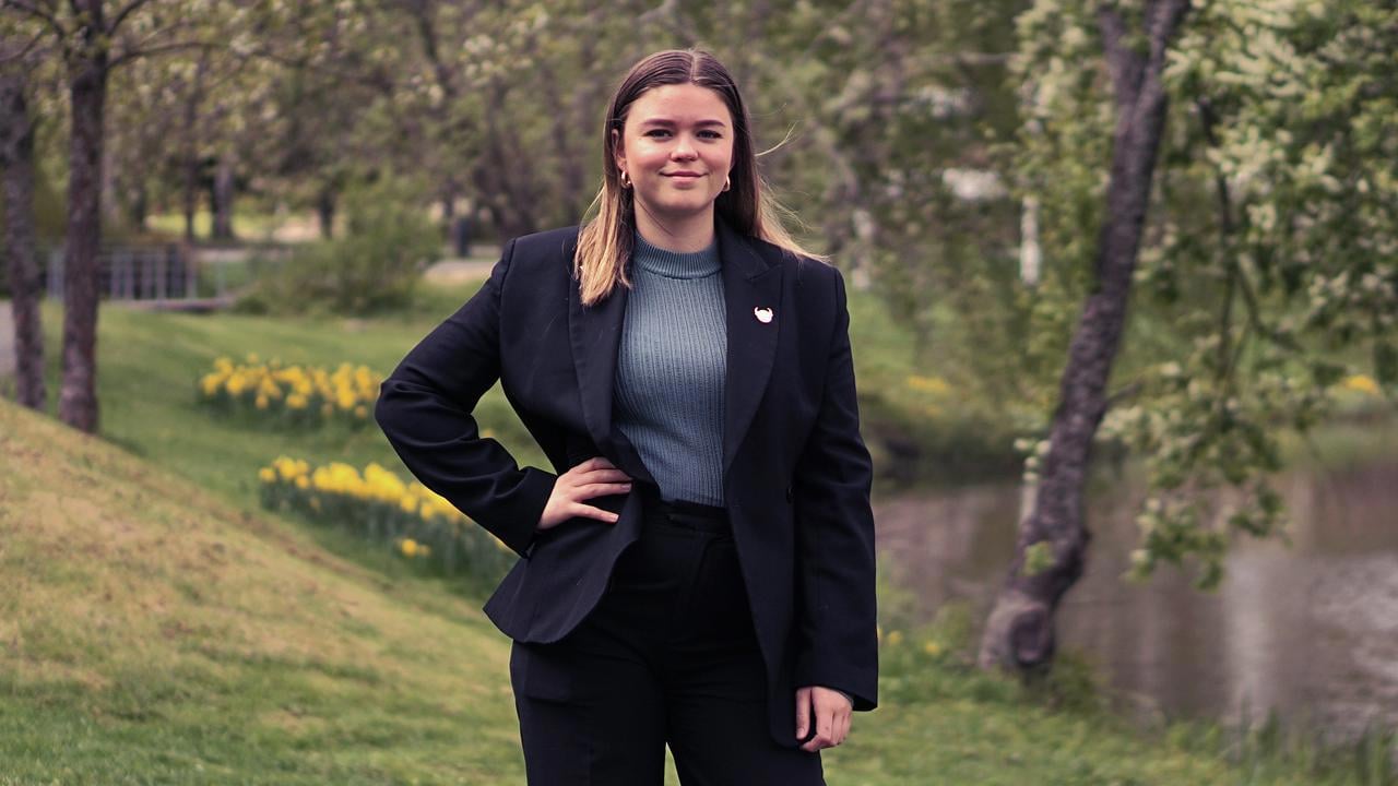 En kvinna i svart kostym st&aring;r framf&ouml;r en flod.