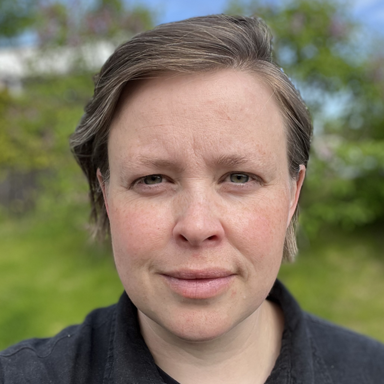 En kvinna i en svart tr&ouml;ja som poserar f&ouml;r en bild.