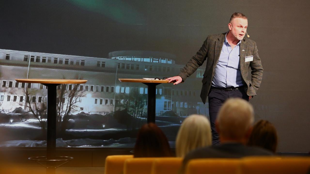 En man som st&aring;r p&aring; ett podium framf&ouml;r en folkmassa.