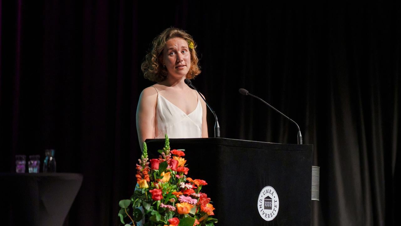 Studenttalare st&aring;r p&aring; ett podium framf&ouml;r en mikrofon.