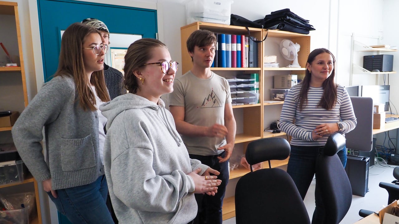 Nils Hauff, staff scientists vid UCEM, visar eleverna Tilda Brännström Skilling, Rocky Andersson, Lovisa Wikman och Leona Stål det stora elektronmikroskopet vid UCEM.