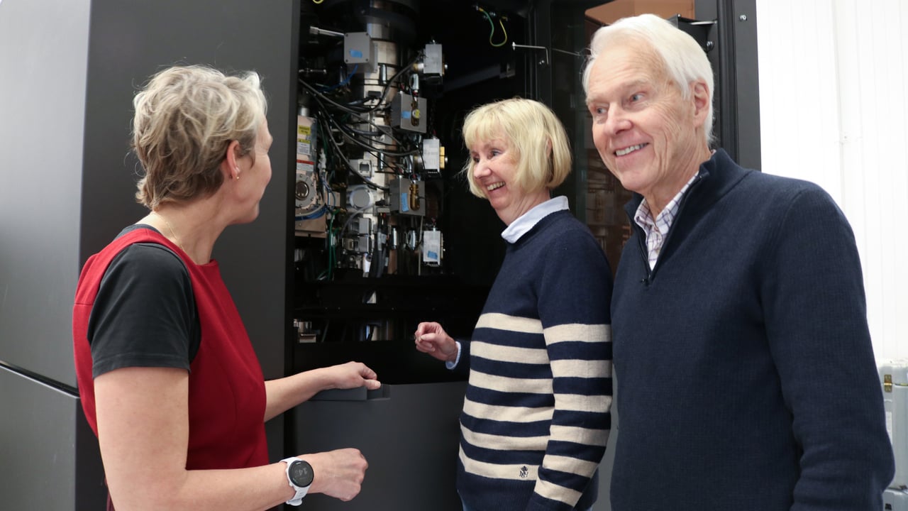 Tre glada personer framf&ouml;r elektronmikroskopet.