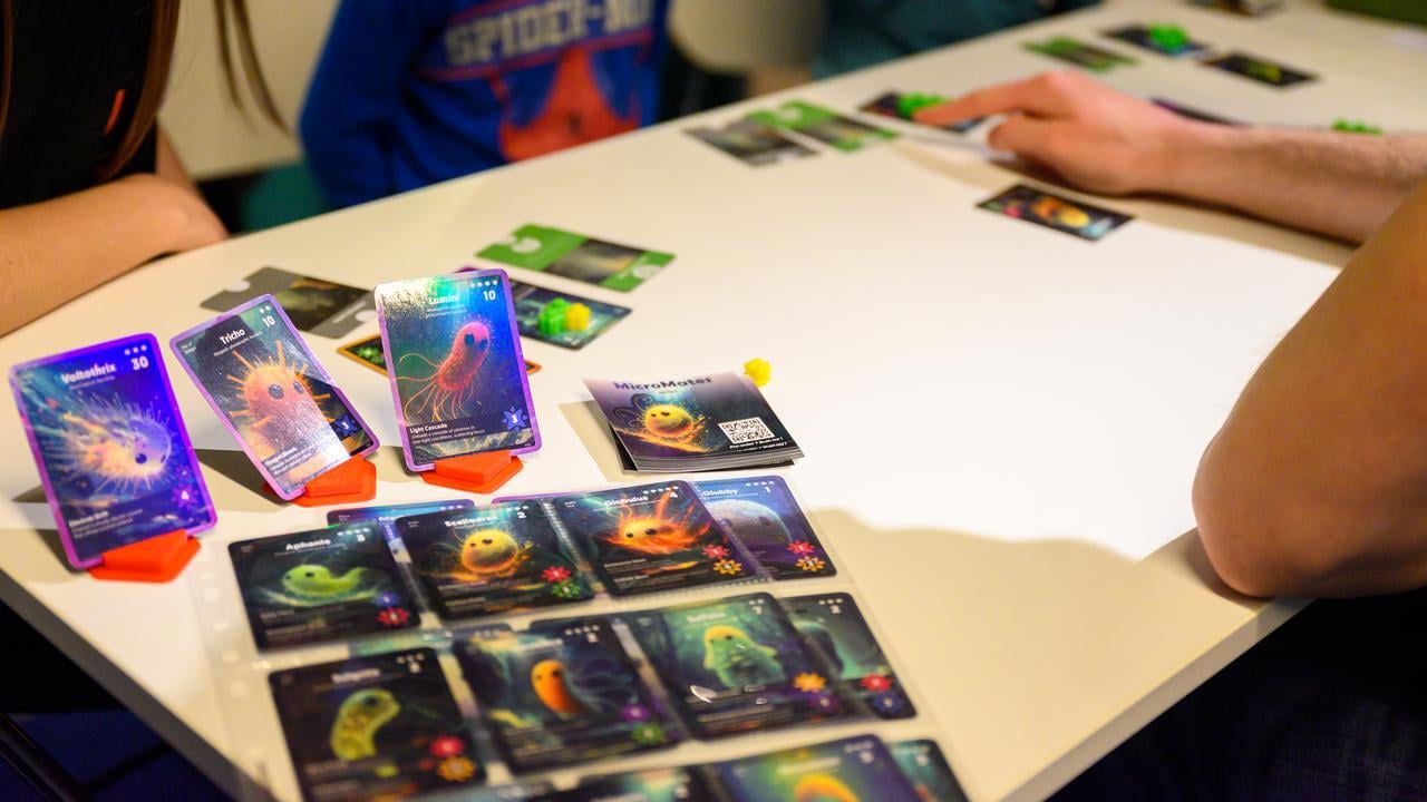 A group of people sitting around a table playing a game.