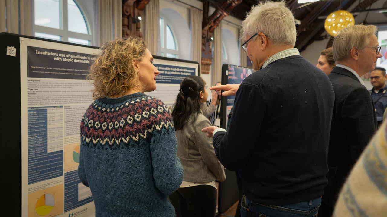 Tv&aring; personer diskuterar framf&ouml;r vetenskapliga posters.