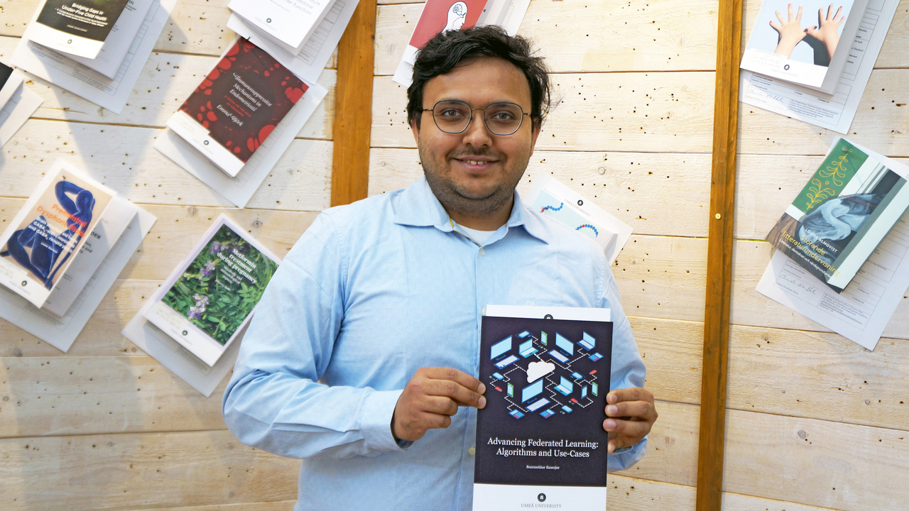 Sourasekhar Banerjee i ljusbl&aring; skjorta h&aring;ller fram sin avhandling som snart ska spikas upp p&aring; Ume&aring; universitetsbibliotek.