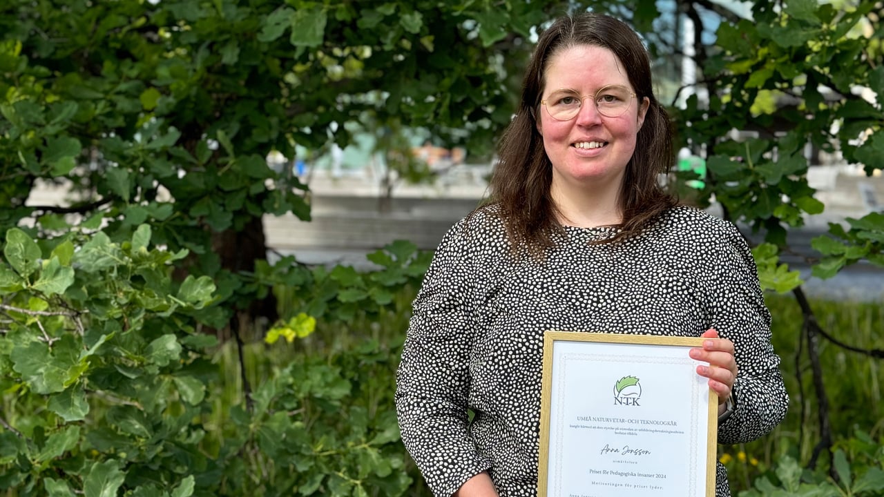 Anna Jonsson, universitetslektor i datavetenskap, har l&aring;ngt h&aring;r och glas&ouml;gon. Hon st&aring;r i en gr&ouml;nskande utemilj&ouml;, och h&aring;ller i sitt diplom.