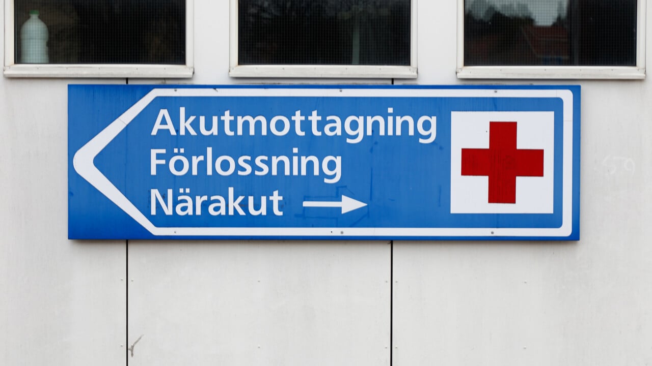 V&auml;gvisande skylt med r&ouml;tt kors vid sjukhus med Akutmottagning, f&ouml;rlossning och n&auml;rakut.
