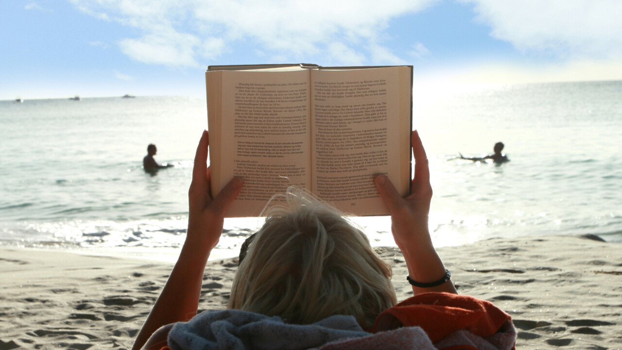 Bild p&aring; bokl&auml;sare p&aring; strand