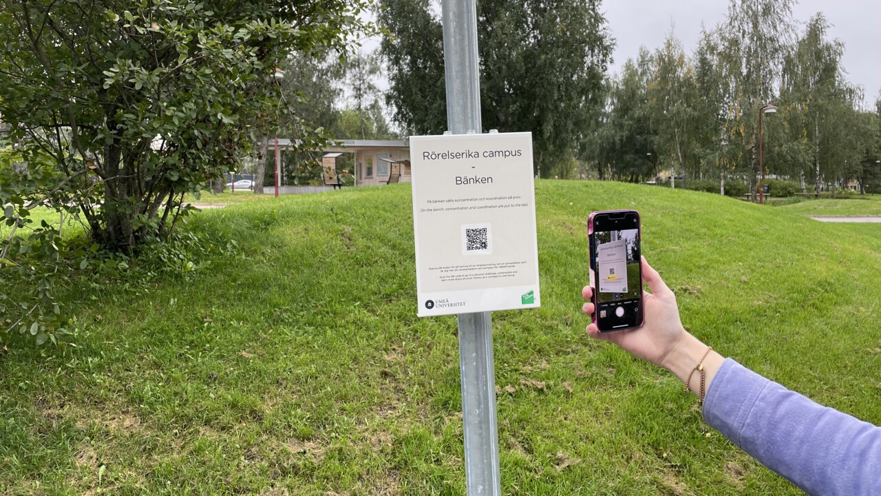 En station i programmet rörelserika campus, mobil skannar QR-kod på skylt.