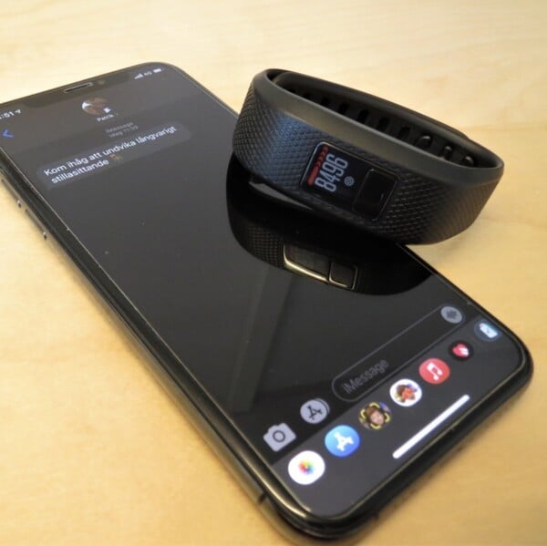 Mobiltelefon och aktivitetsband med appen mHealth &ouml;ppen