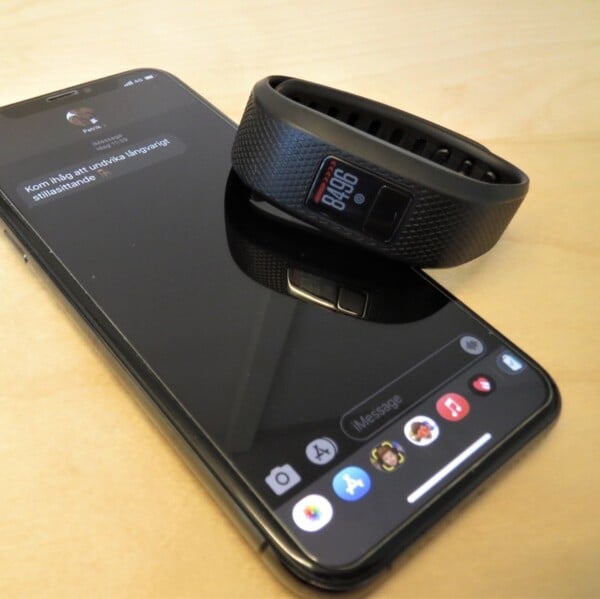 Mobiltelefon och aktivitetsband med appen mHealth &ouml;ppen