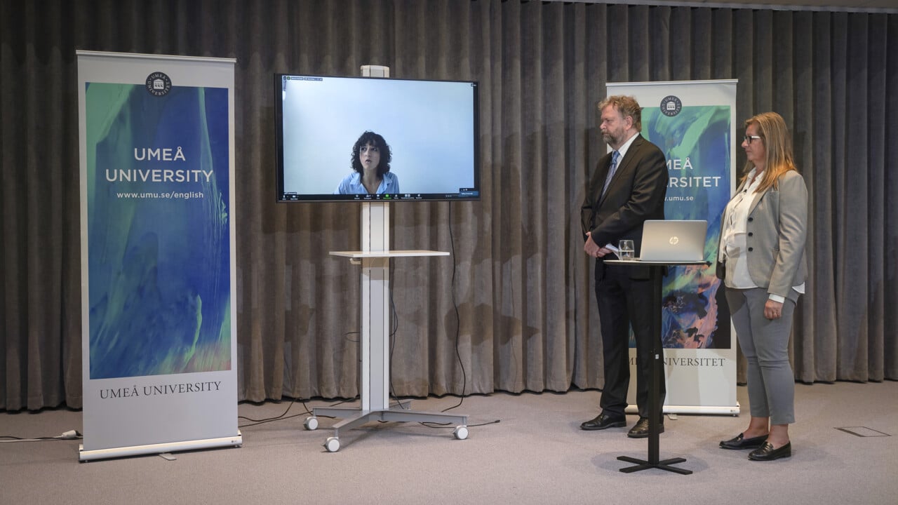 Emmanuelle Charpentier p&aring; l&auml;nk fr&aring;n Berlin under presskonferensen. Ola Nilsson, kommunikat&ouml;r vid Kansliet f&ouml;r medicin, var moderator och hade Katrine Riklund, prorektor, vid sin sida.