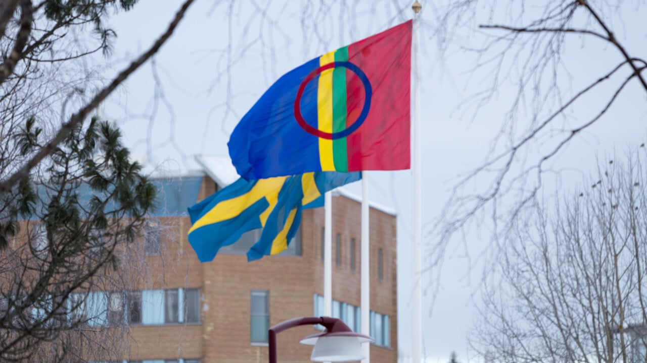 Den samiska flaggan vajar bredvid tv&aring; svenska p&aring; flaggst&auml;ngerna p&aring; campus Ume&aring;.