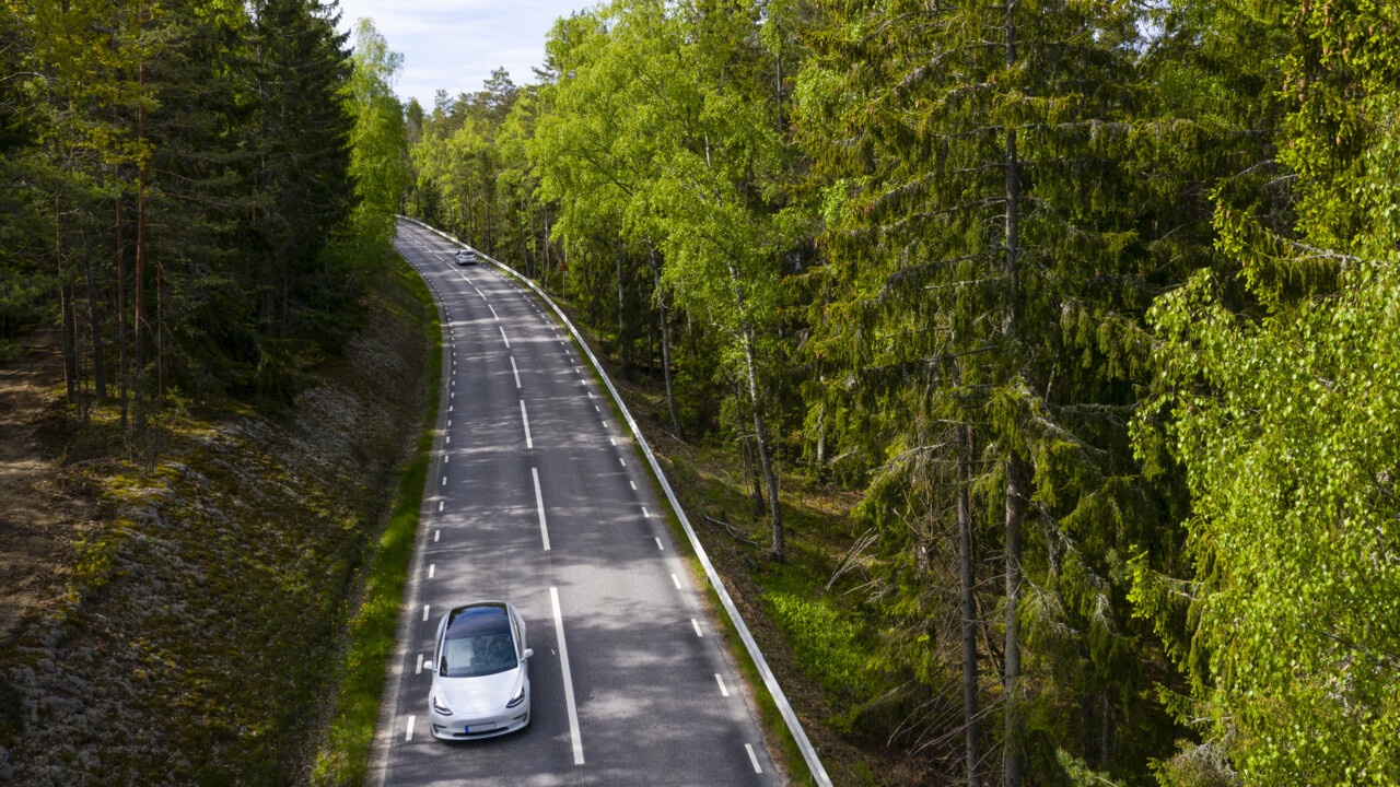 Bild p&aring; bil som k&ouml;r p&aring; v&auml;g genom skogen