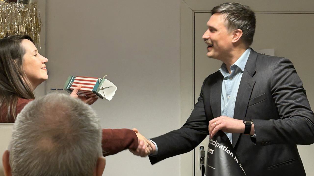 A man in a suit shaking hands with a woman