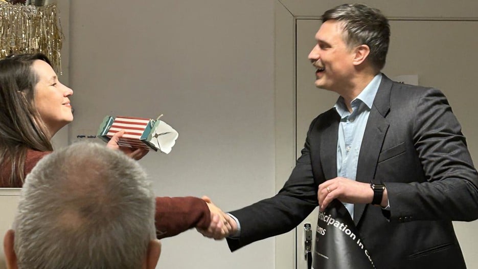 A man in a suit shaking hands with a woman