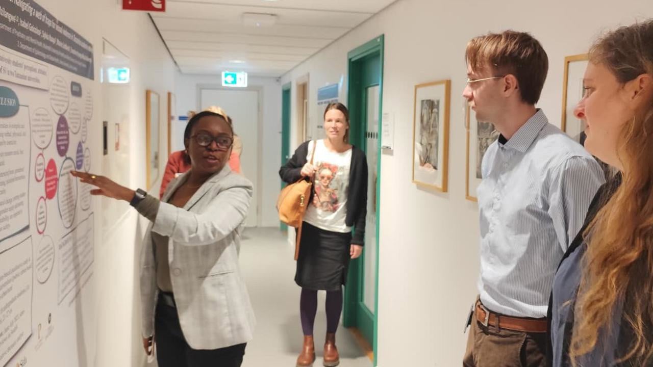 A group of people standing around a white board.