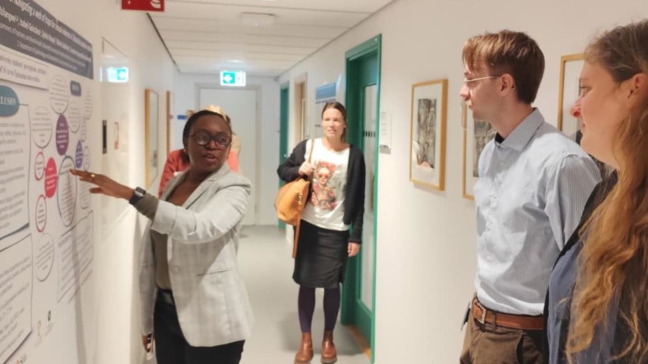 A group of people standing around a white board.