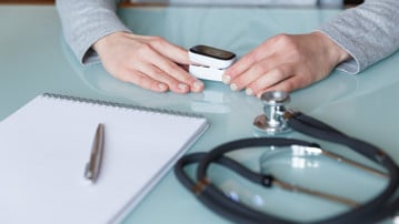 Female patient hand measuring oxygen saturation and pulse using portable oximeter. Health care concept