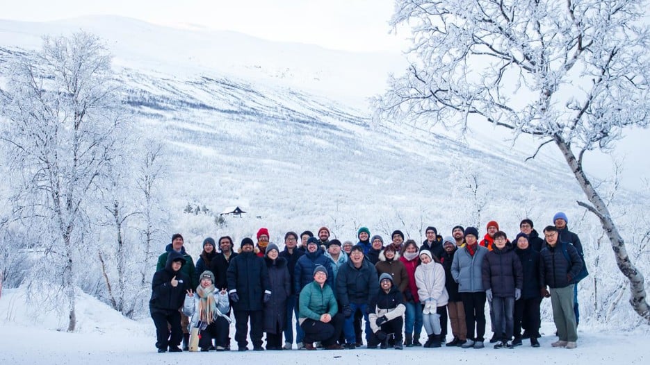 A group of people standing next to each other in the snow.