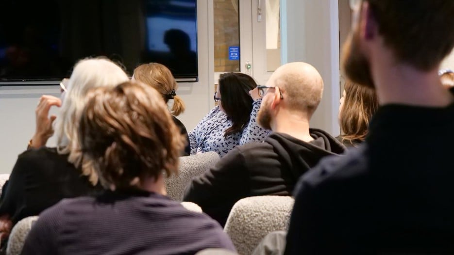 En grupp människor som sitter i ett rum och tittar på en presentation.