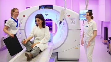 Patient med vårdpersonal på nuclearmedicinsk sjukhusavdelning