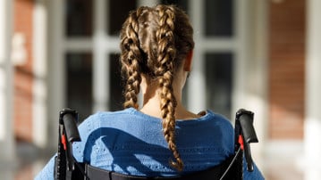 Flicka med flätor i rullstol