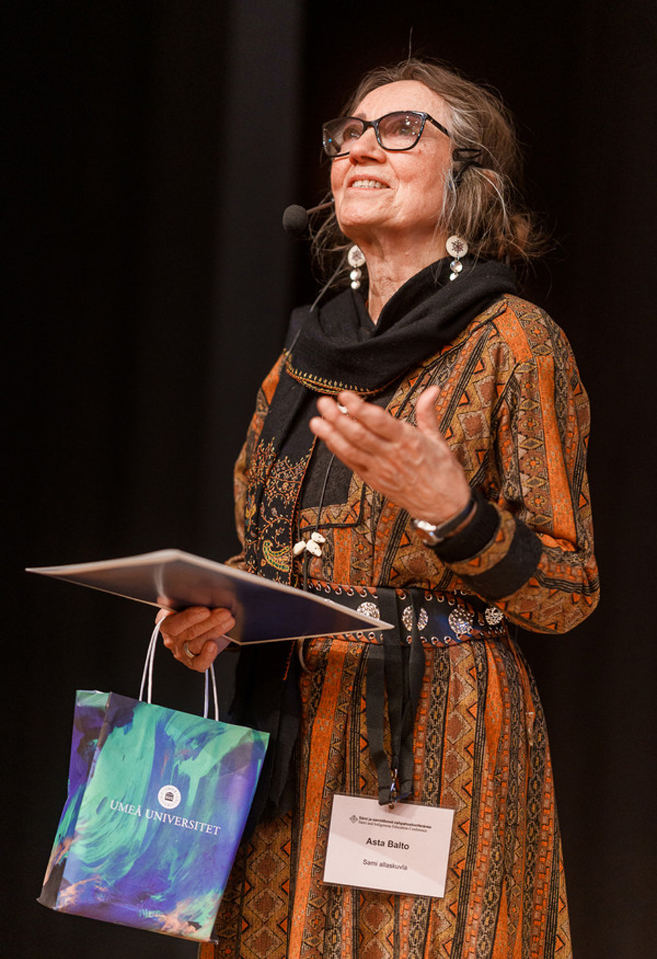Asta Balto stands on a stage and has just received Várdduo's Scientific Award 2025.