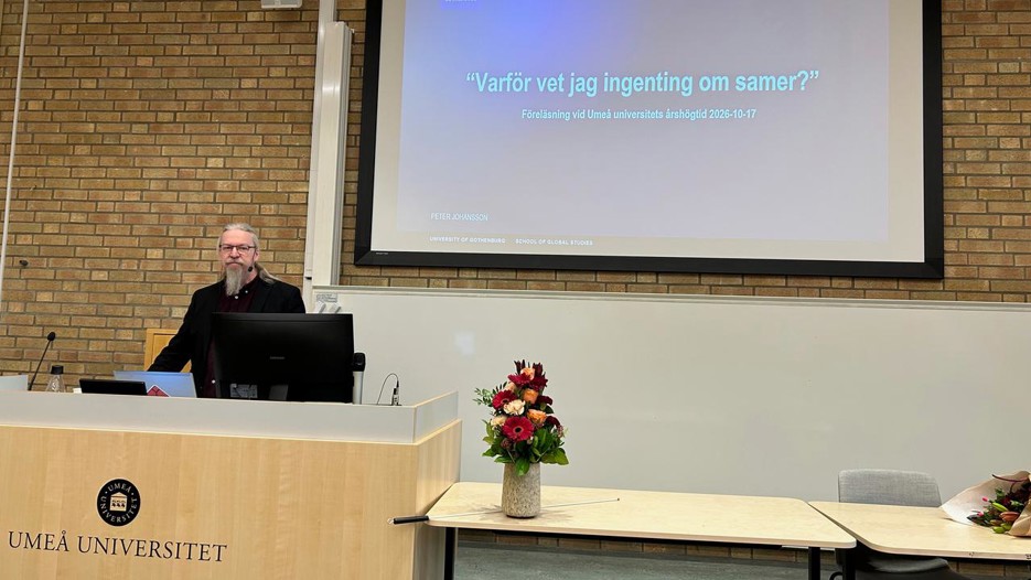 Peter Johansson stands behind a podium with a powerpoint behind him that reads "Why don´t I know anything about the Sámi?" in Swedish.