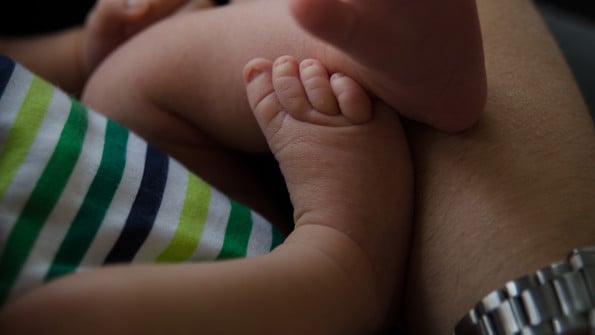Två veckor gammal baby sprattlar med fötterna. Genrebild från Mostphotos för att illustrera spädbarn, förlossningsvård.