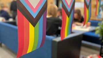 LGBTQI-flag and students in a sofa