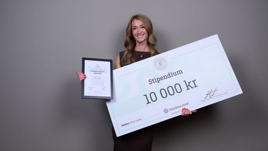 Olivia Lundin som håller en stor check och ett diplom i händerna.