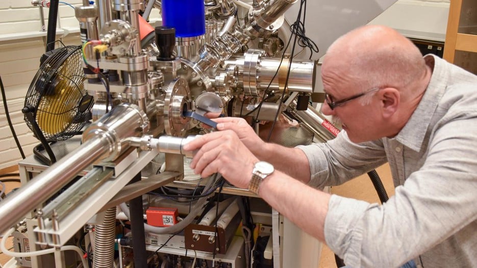 Andrey inserts a sample in the XPS-instrument.