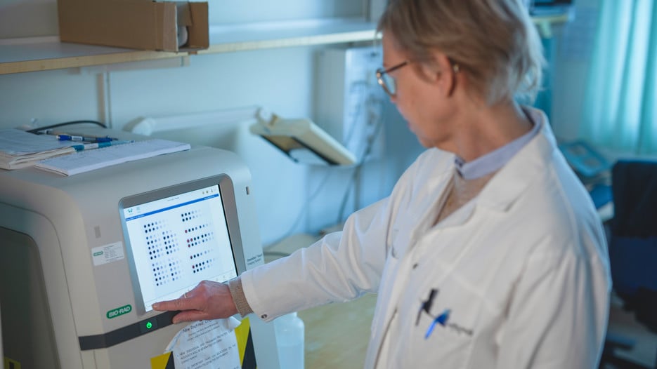 Helena Alstermark is standing by a Chemidoc imager, used to detect and visualise chemiluminescence from immunolabelled samples on a dot blot membrane.