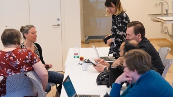 Studenter kring bord som diskuterar