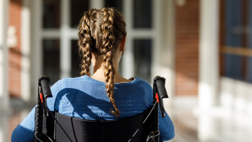 Flicka med flätor i rullstol