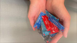 Två händer som håller i kondomer. Ska symbolisera att Studenthälsan erbjuder gratis testning av sexuellt överförbara infektioner samt erbjuder gratis kondomer.