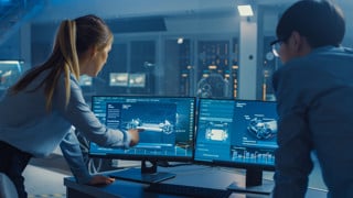 Female and Male Engineers are Discussing the 3D CAD Software Render of an Electric Concet Car. High Tech Laboratory with a Prototype Vehicle Chassis.