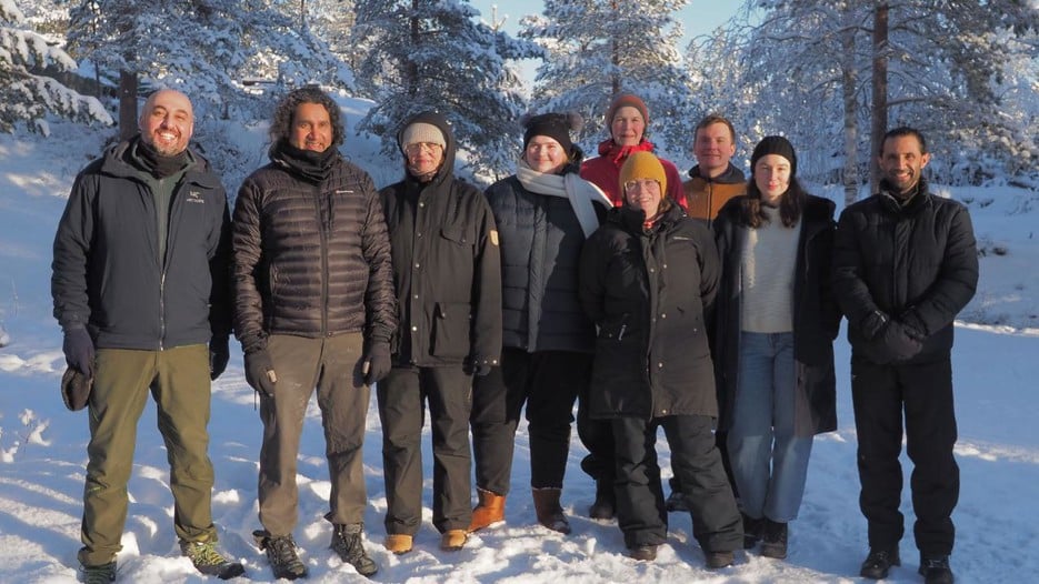Group of people standing in the snow with a background of winter landscape