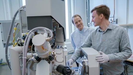 – Erik Olof WikLund, konstnär och examinerande masterstudent vid Konsthögskolan, Umeå universitet
– Nils Hauff, staff scientist, Umeå Centre for Electron Microscopy, Umeå universitet, SciLifeLab 

Erik Olof Wiklund, artist, and Nils Hauff, staff scientist at UCEM, has been using a FIB-SEM (focused ion beam-scanning electron microscope) to carve out the microscopic Dala horse from a piece of platinum. Photo: Mattias Pettersson, Umeå University.