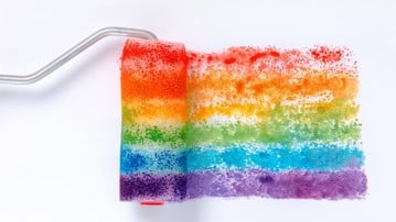Rainbow-coloured flag painted using a paint roller.