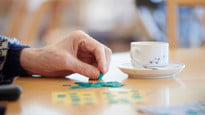 Närbild äldre hand som spelar bingo.