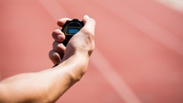Hand holding a stopwatch on running tracks. Genrebild från Mostphotos.