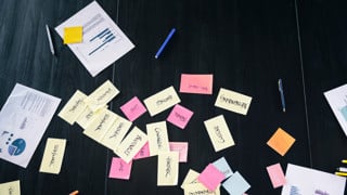 Post it-lappar och pappersutskrifter på bord