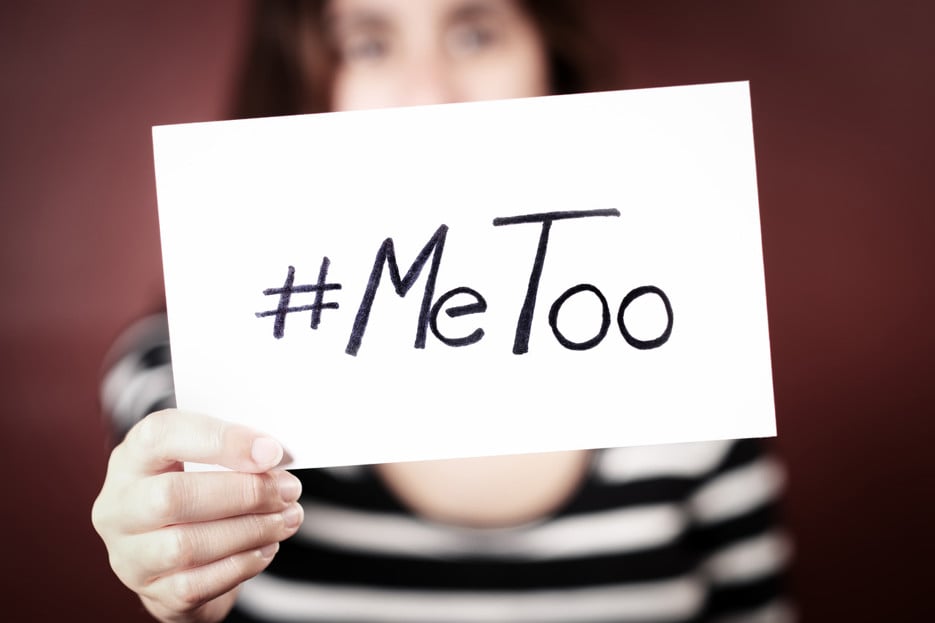 En kvinna som håller upp en skylt med texten "MeToo".