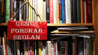 Broderad genusforskarskoleskylt på bokhylla