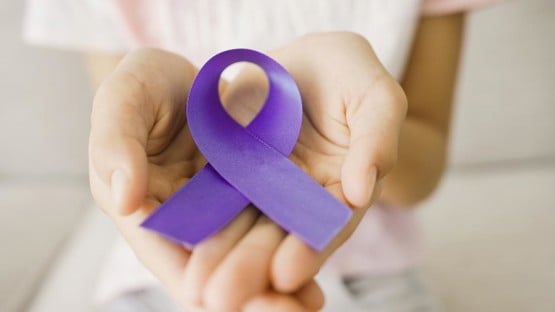 Hands holding purple ribbon, Alzheimer's disease, Pancreatic cancer, Epilepsy awareness, world cancer day, cancer survivor day, concept